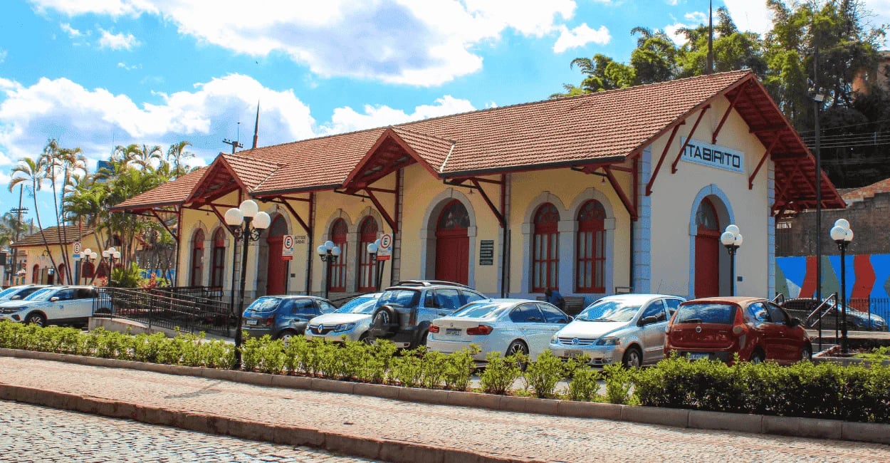 Antiga Estação Ferroviária de Itabirito, um prédio histórico amarelo com telhado de barro e portas e