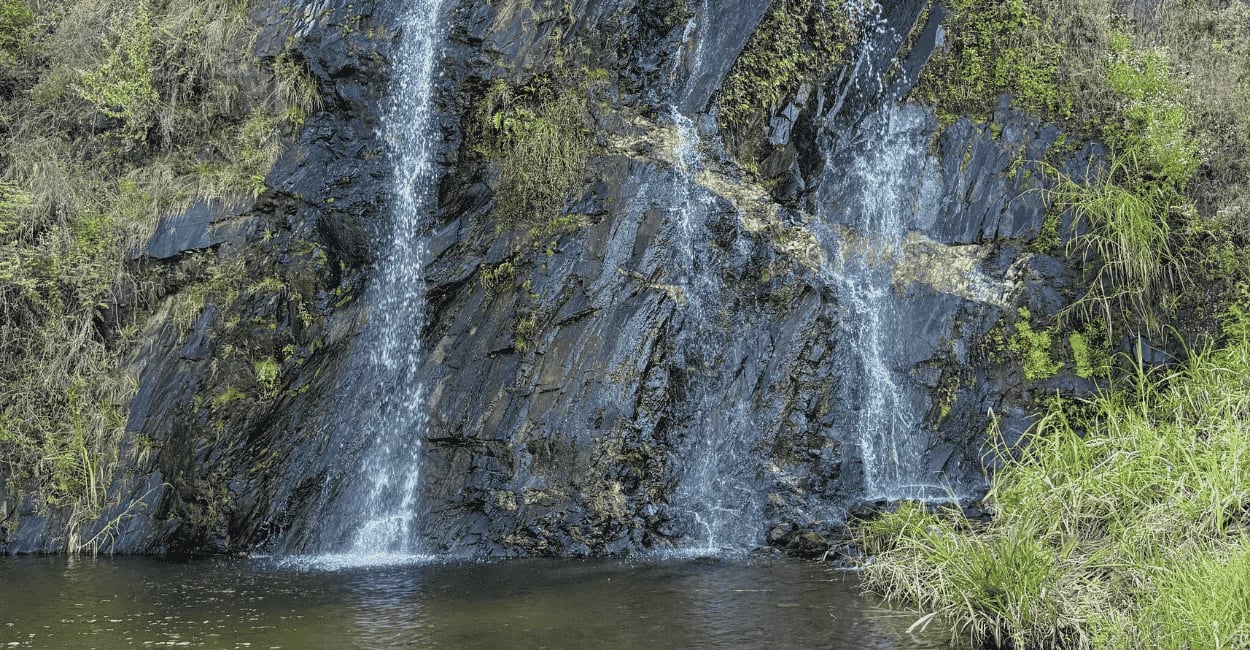 Cachoeira da Santa em Catas Altas com quedas d’água sobre paredão rochoso e poço em meio à vegetação