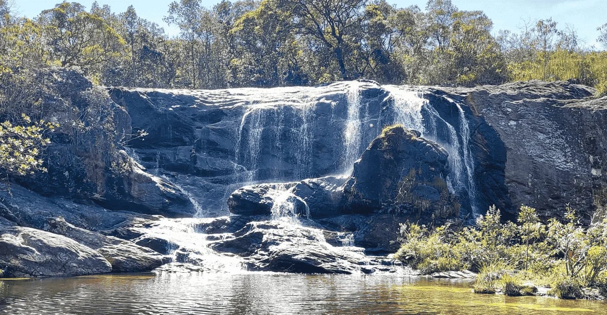 Cachoeira do Leão em Cocais com queda d’água sobre pedras, poço natural e mata ao redor
