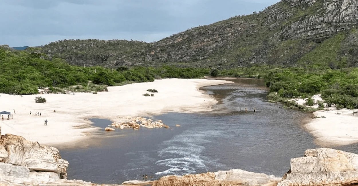 Cachoeira do Telésforo em Conselheiro Mata MG, com rio de águas escuras, faixa de areia clara