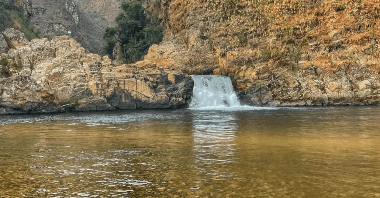 Cachoeira do Zé Carlinhos, pequena queda d’água entre pedras, poço raso de água clara, Delfinopolis