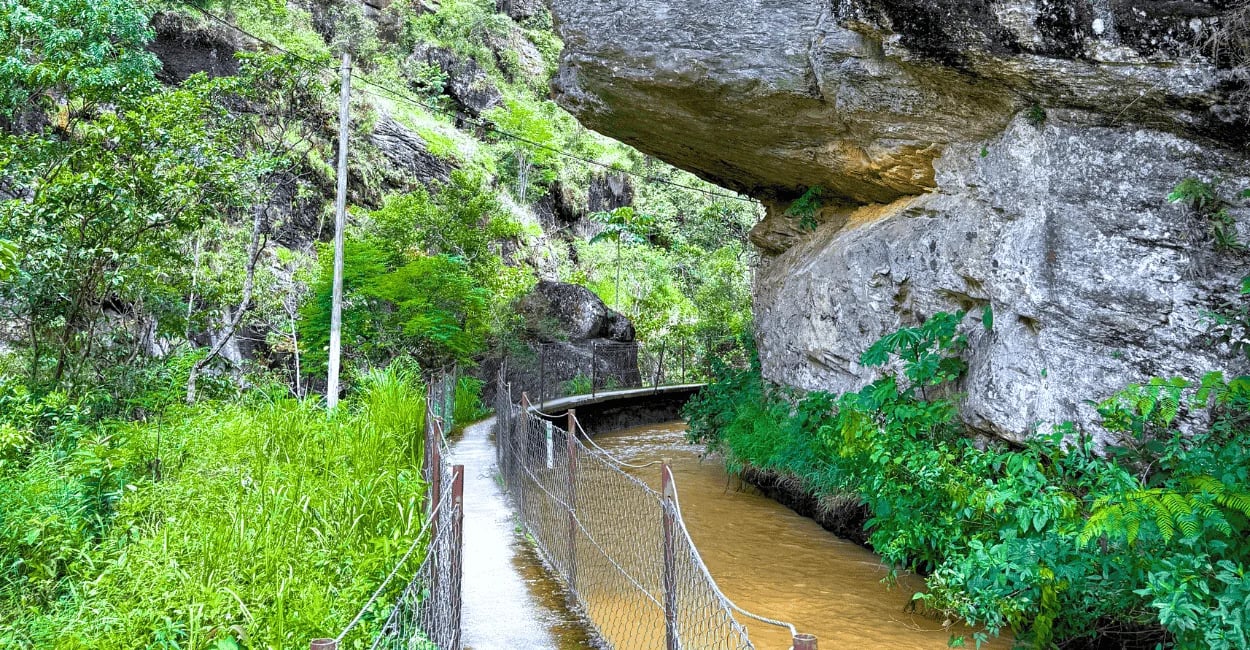 Passarela com rio ao lado, pedras e vegetação na passarela do funil em Santo Antonio do Salto