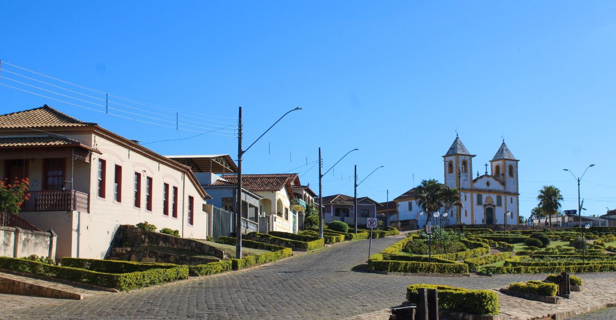 Igreja Histórica e casas na Praça Central de Queluzito, Cidade no Interior de Minas Gerais