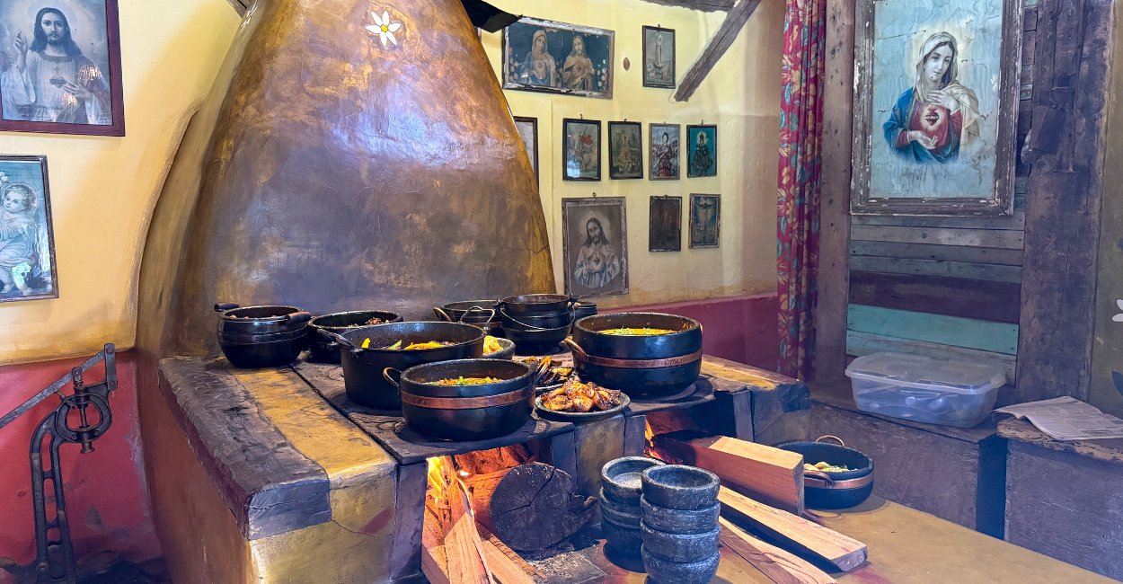 Fogão de lanha, com panelas de pedra, quadros antigos e comina mienira, em Itatiaia, MG