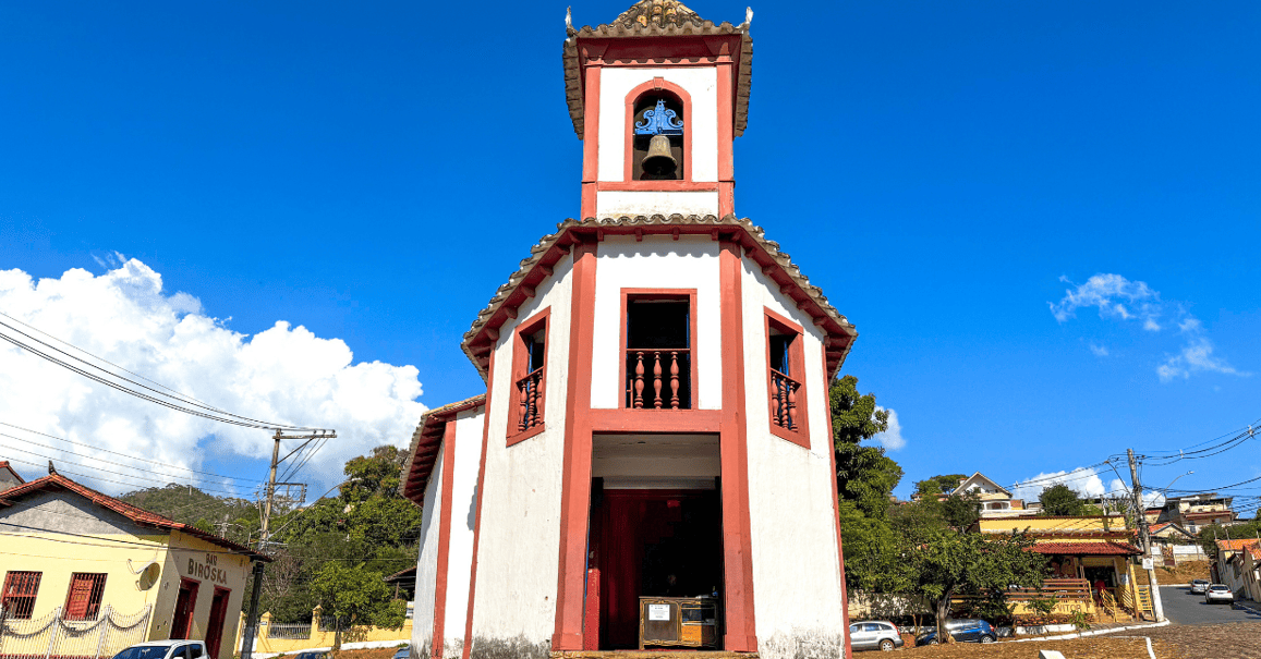 Capela de Nossa Senhora do Ó, com cores azul e branca, com céu azul em Sabará MG
