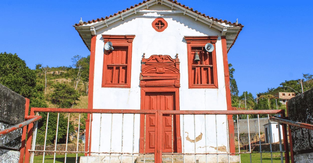 Capela de Nossa Senhora do Rosário em Itapanhoacanga MG com fachada branca, detalhes vermelhos