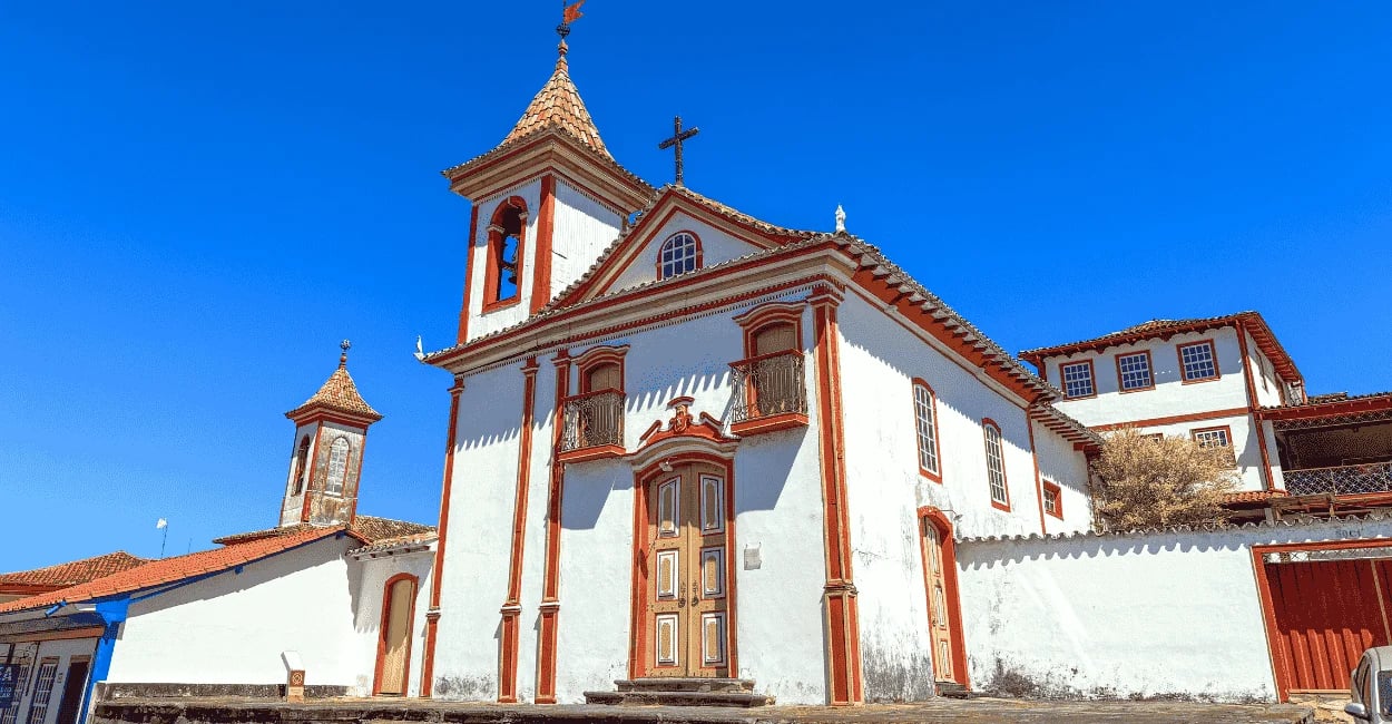 Capela histórica em Diamantina MG com fachada branca e detalhes vermelhos sob céu azul