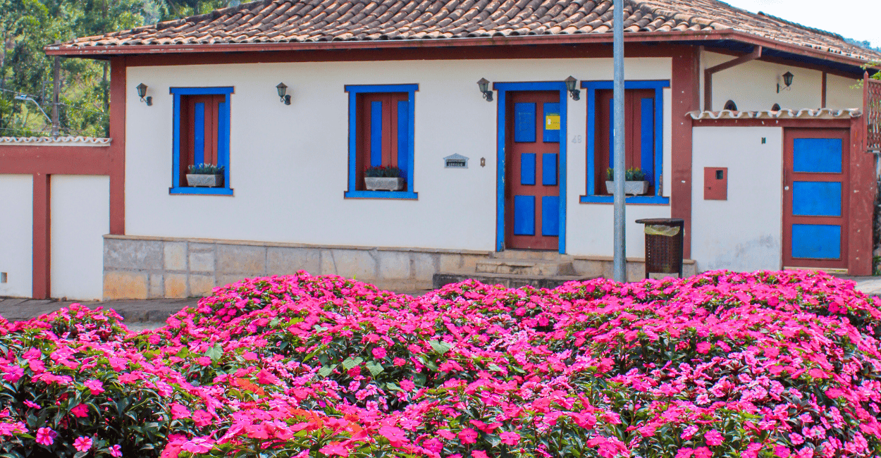 Casa histórica do periodo colonial com um lindissimo jardim com flores rosas a frente, Santa Bárbara