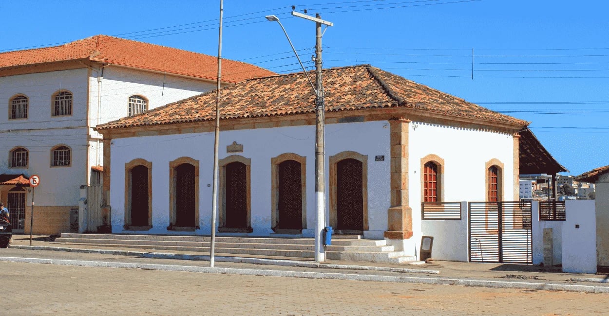 Casario histórico de Ouro Branco com fachada colonial branca, portas de madeira e telhado antigo