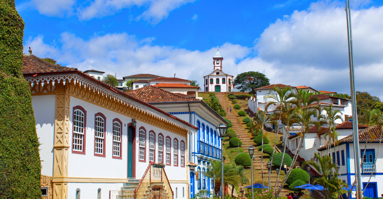 Casarões históricos, com uma escadaria de pedras e a igreja no alto, cidade turistica de Serro em MG