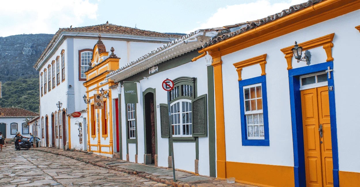 Rua de pedra com casario colorido e arquitetura colonial em Tiradentes, Minas Gerais