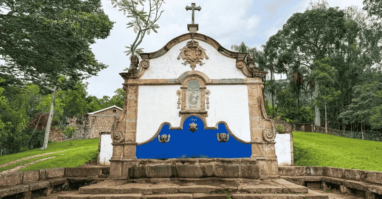 Chafariz de São José, construção histórica de pedra sabão, com cores brancas e azuis, com vegetação 