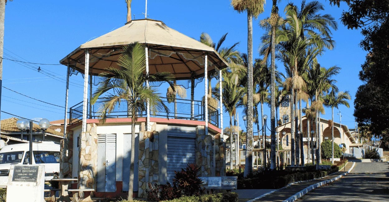 Coreto da praça em frente à Igreja Matriz de Casa Grande, cercado por palmeiras e jardins