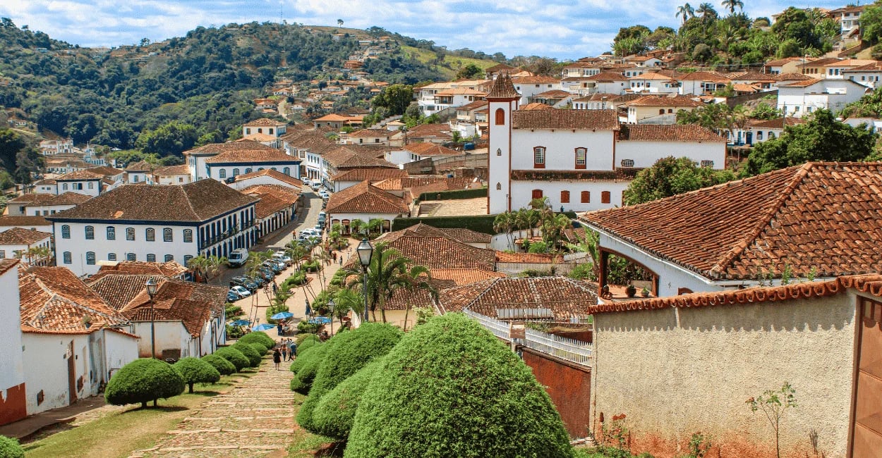 Vista histórica de Serro, com casario colonial, escada e ruas de pedra, igreja e morros ao redor