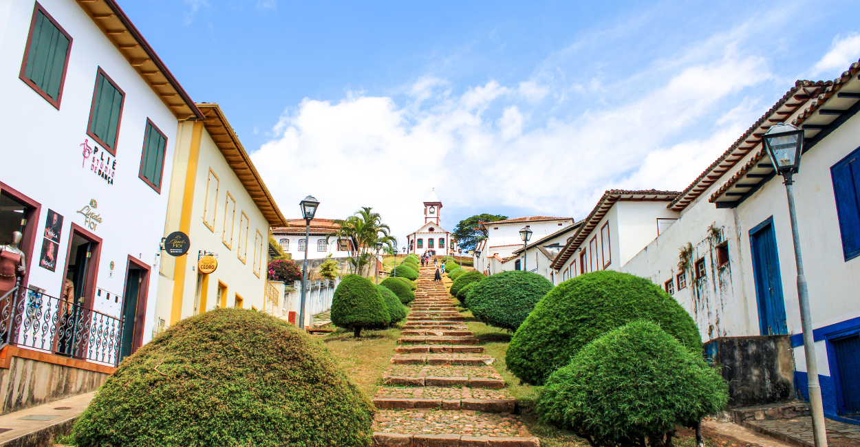 Casarões históricos, com uma escadaria de pedras e a igreja no alto, cidade turistica de Serro em MG