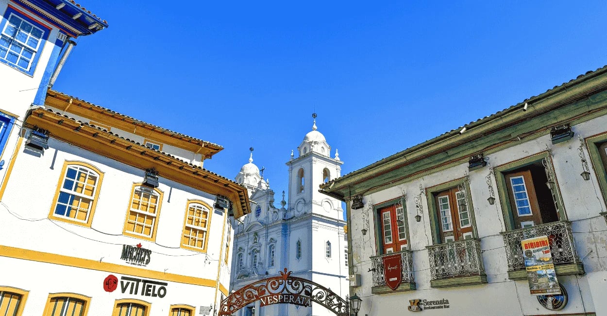 Pórtico escrito Vesperata cercado por casarões e a Catedral Metropolitana ao fundo em Diamantina