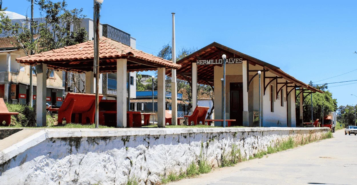 Antiga estação Ferroviária no distrito de Hermilio Alves, com bancos de cor vemelha e ceu azul