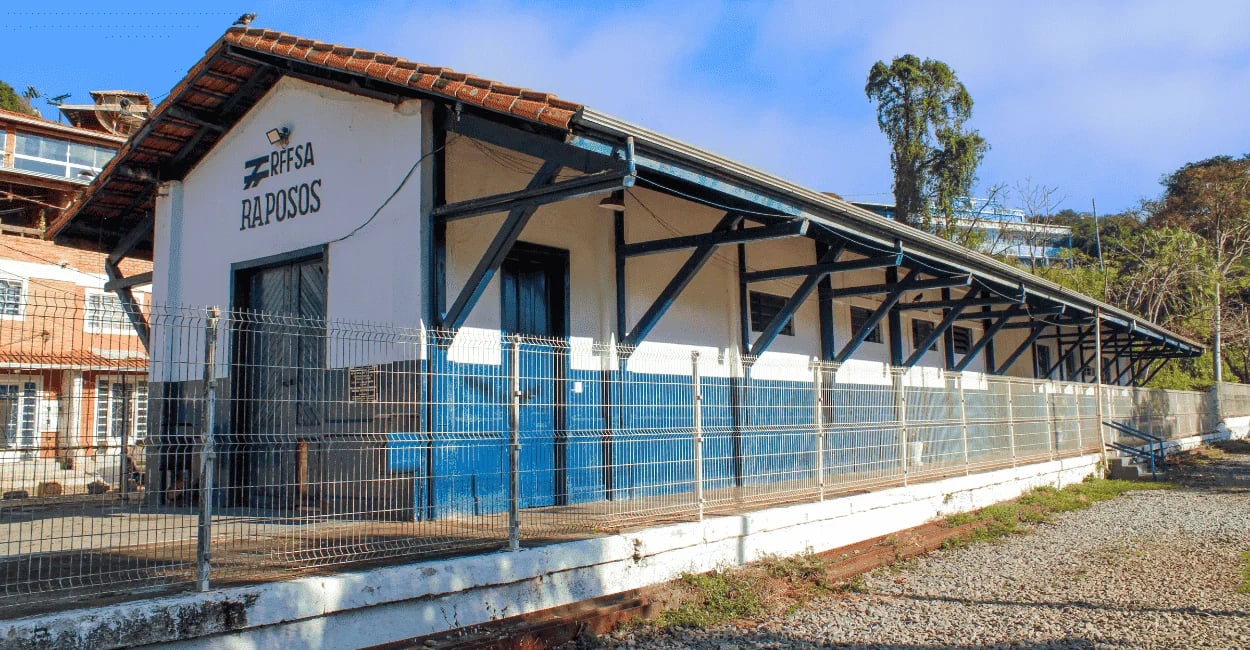Antiga estação ferroviária branca e azul com o letreiro RFFSA Raposos. Minas Gerais