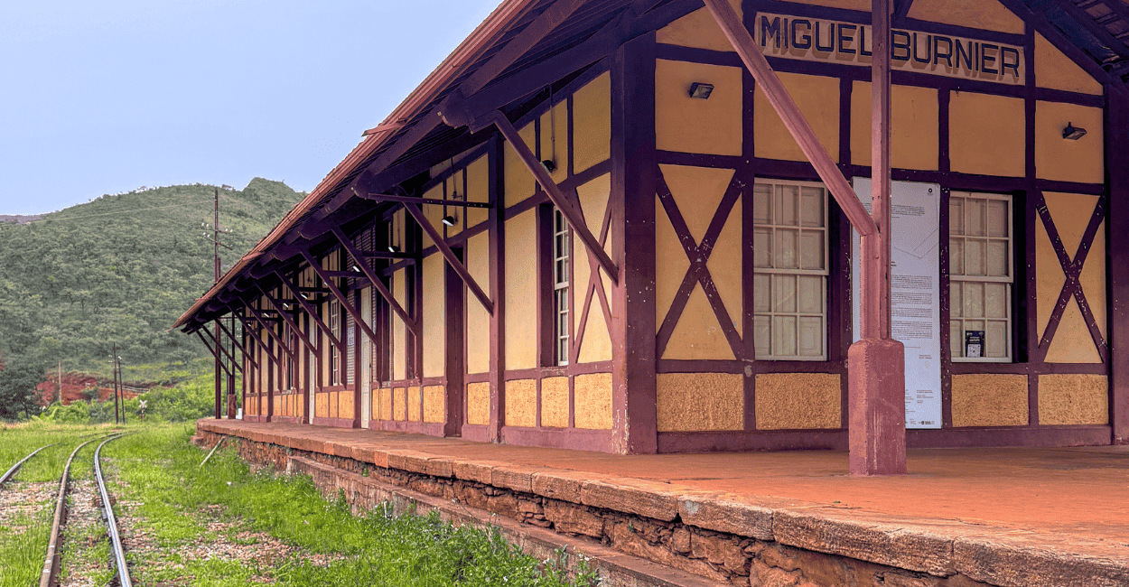 Estação Ferroviária de Miguel Burnier, cor amarela e marrom, com trilho ao lado