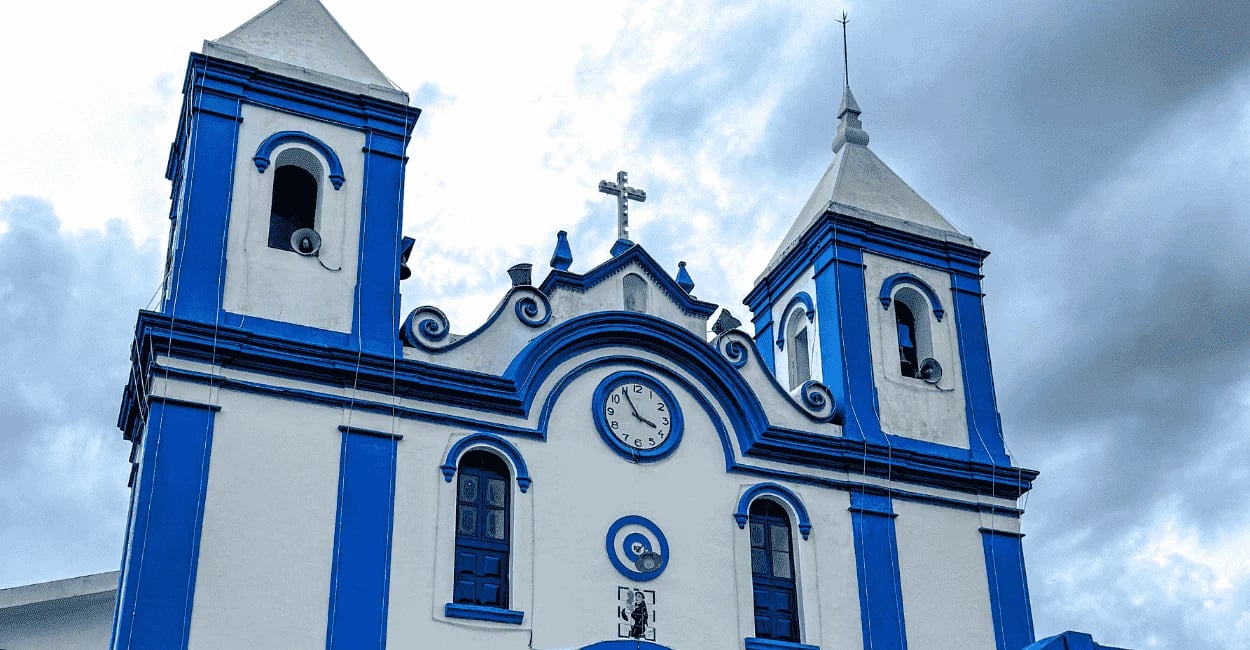 Igreja de Santo Antônio do Leite com fachada branca, detalhes azuis e relógio central