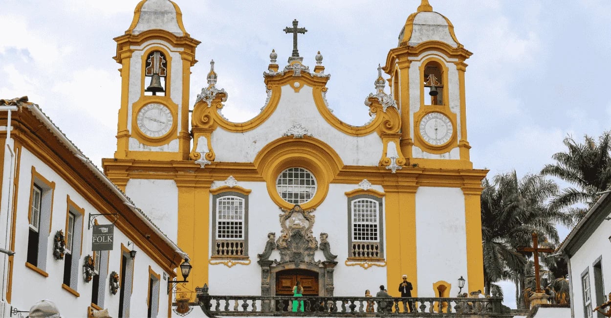 Igreja Matriz de Santo Antônio em Tiradentes com fachada barroca, torres amarelas e cruzeiro históri