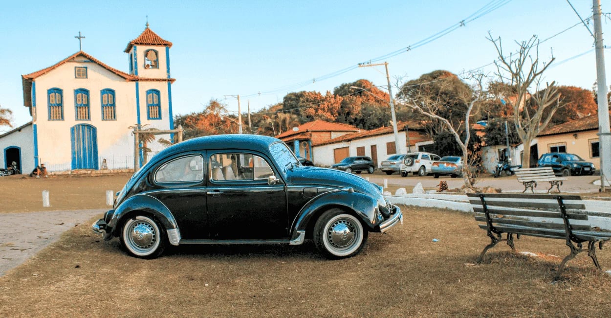 Fusca preto antigo estacionado na praça principal de Extração, Diamantina, em frente à igreja