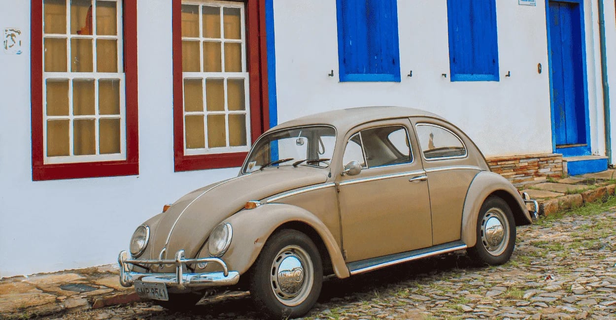 Fusca de cor marrom, ruas de pedras e casas do periodo colonial atrás em Ouro Preto MG