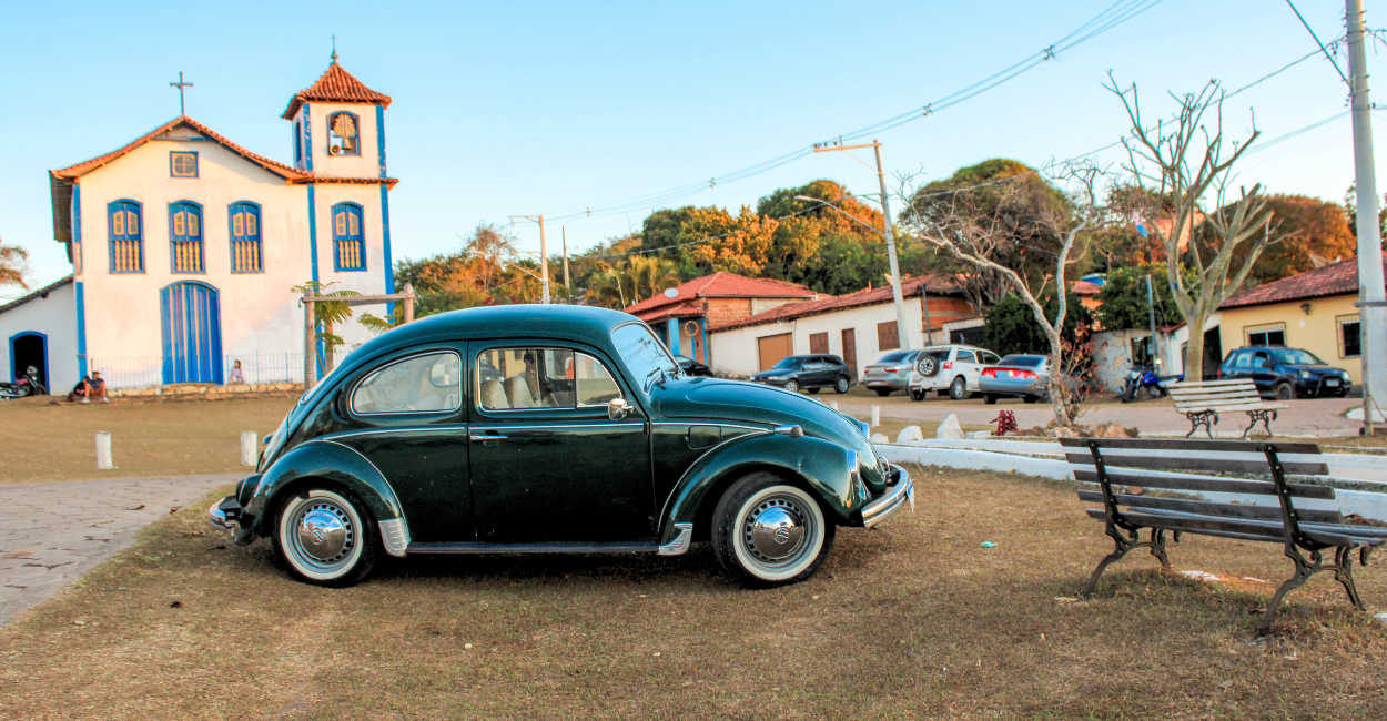 Fusca com uma igreja historica ao fundo, em Curralinho/extração, distrito turistico de Diamantina MG