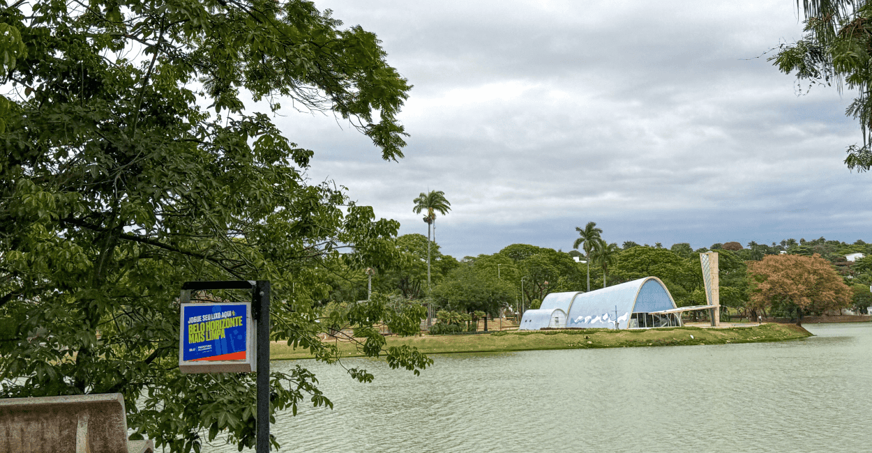 Lagoa da Pampulha com uma árvore, água e a igrejinha ao fundo, em Belo Horizonte MG