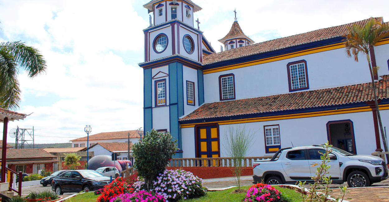 Igreja Matriz de Datas, na praça com flores. Ponto turistico de Minas Gerais
