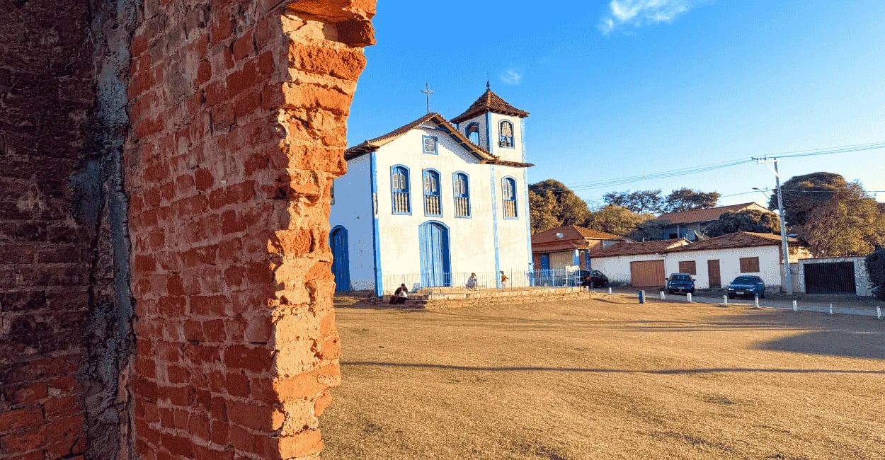Igreja histórica em Curralinho, distrito de Diamantina MG, com parede de tijolos em primeiro plano