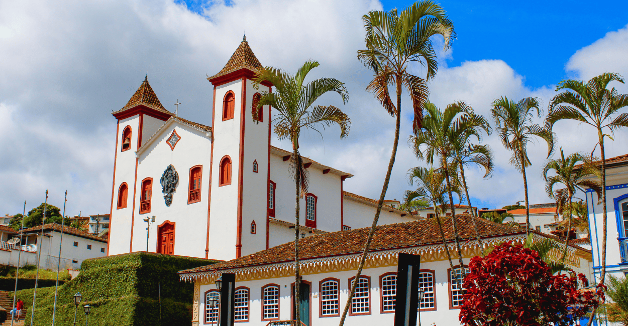 Igreja histórica, com casa do periodo colonial e coqueiros em Serro Minas Gerais