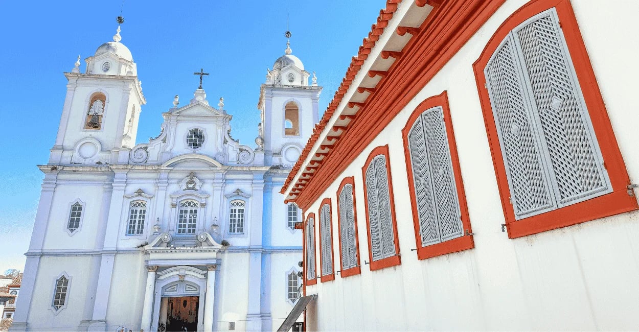Igreja Matriz de Diamantina ao lado de um casarão colonial branco com detalhes vermelhos