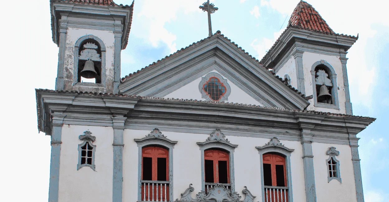 Igreja Matriz de Santa Bárbara, MG, com fachada branca, torres sineiras e janelas centrais