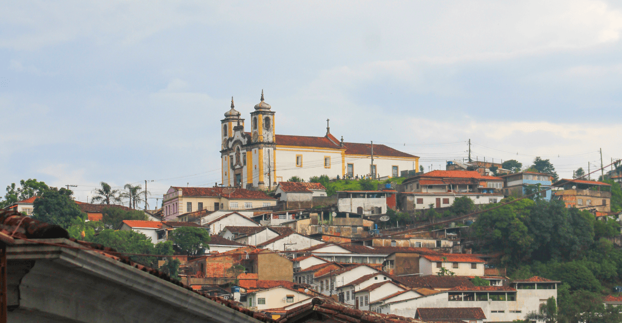 Igreja no Alto, casas abaixo e céu nublado em Ouro Preto Minas Gerais