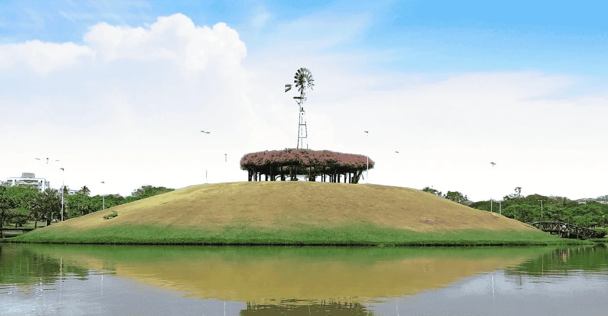 ilha com moinho de vento, agua ao lado, céu com nuvens no Parque Ipanema em Ipatinga