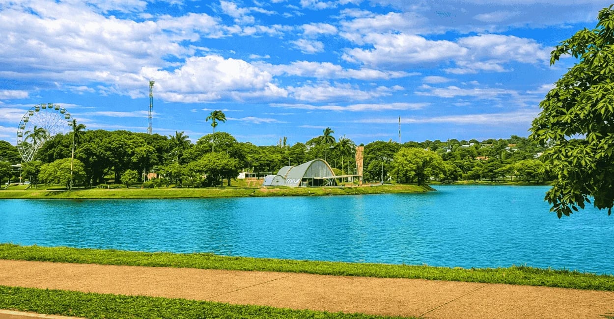 Lagoa da Pampulha, com céu azul e poucas nuvens, árvores nativas e igrejinha da pampulha