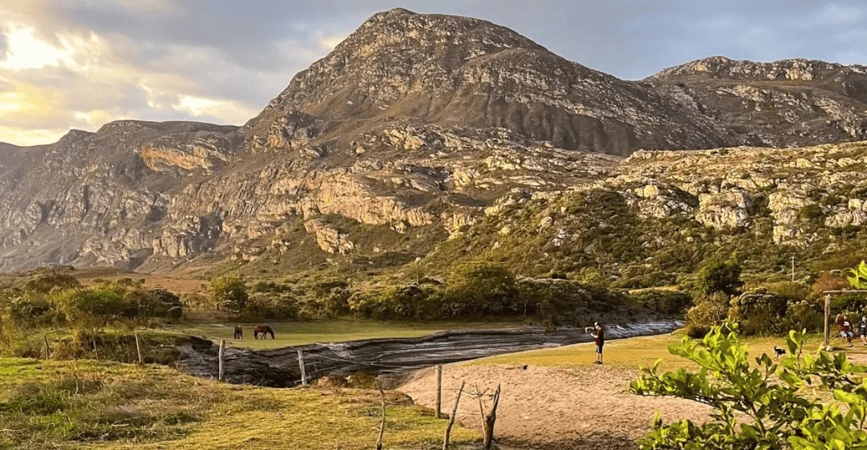 Montanhas de Lapinha da Serra ao entardecer, com campo aberto, lagoa rasa e paisagem rochosa