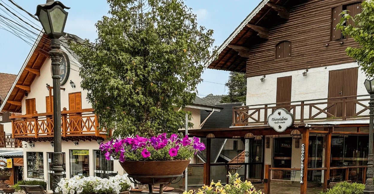 Arquitetura charmosa de Monte Verde MG com chalés em estilo alpino, lojas, flores e clima serrano