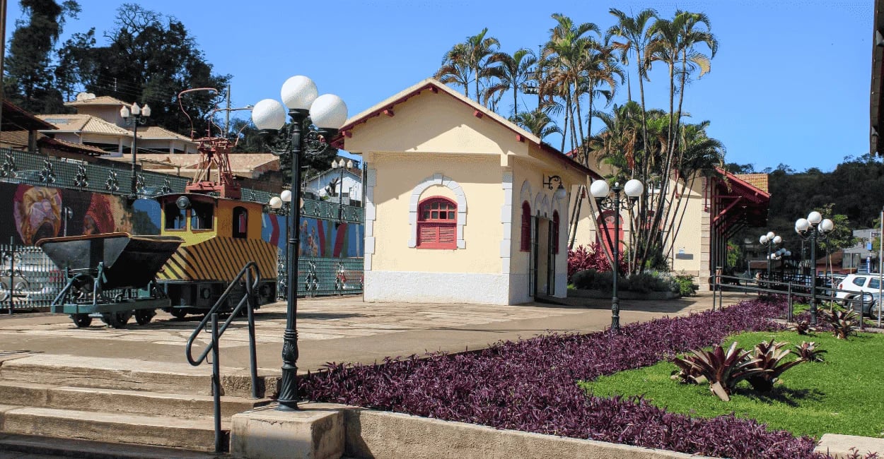 Antiga estação em Itabirito com jardineiras, poste colonial e pequeno trem em exposição