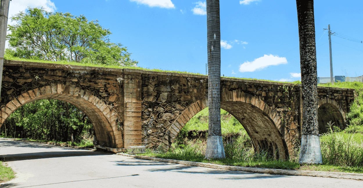 Pontilhão Dom Pedro II em Alfredo Vasconcelos visto da rua com arcos históricos e área verde