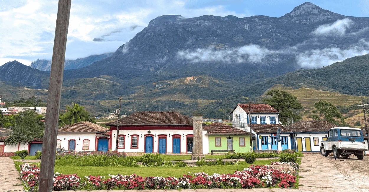 Casario histórico de Catas Altas com a Serra do Caraça ao fundo em Minas Gerais, flores e montanhas