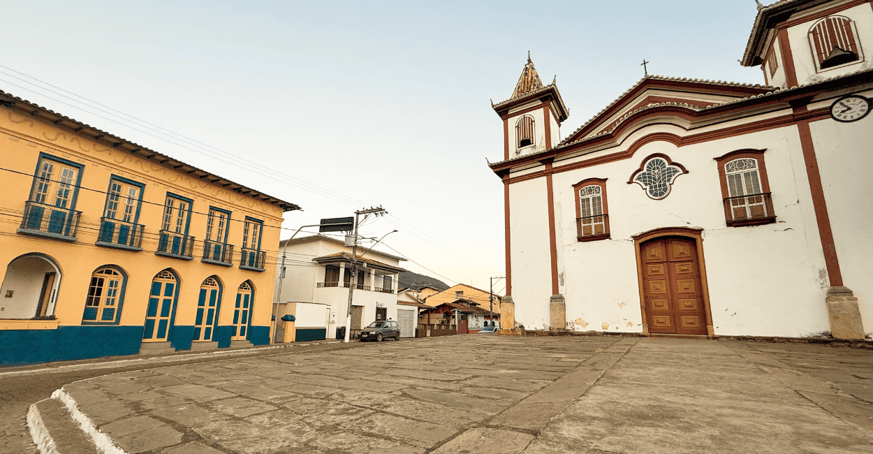 Casarão histórico amarelo e azul, igreja Matriz de cor branca e vermelha em Conceição do Mato Dentro