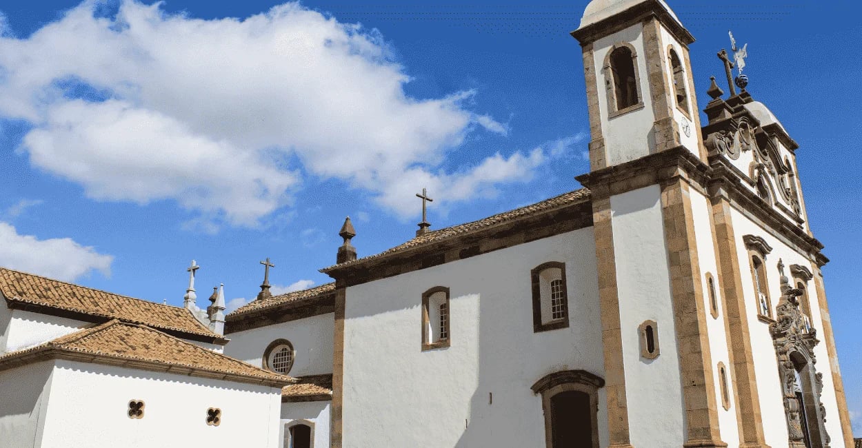 Santuário do Bom Jesus de Matosinhos em Congonhas MG, com igreja histórica, torres e céu azul ao fun