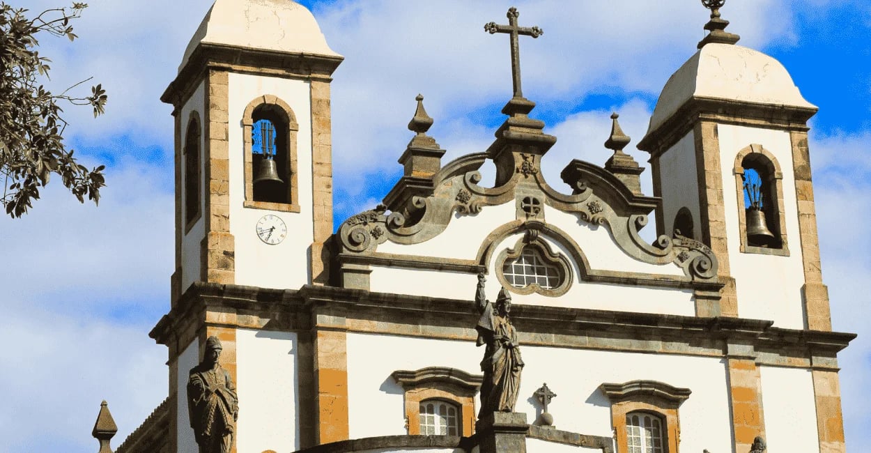 Parte frontal do Santuário do Bom Jesus de Matosinhos em Congonhas, torres, cruz central e profeta