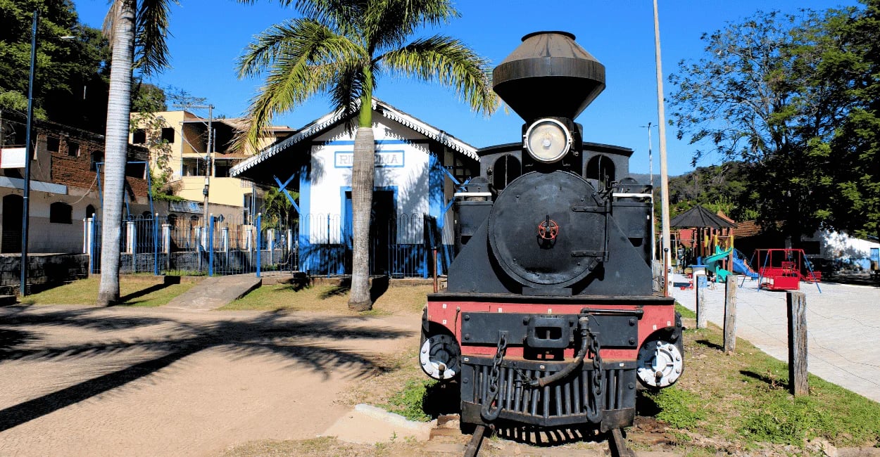 Trem histórico em Rio Acima MG em frente à antiga estação ferroviária e praça arborizada