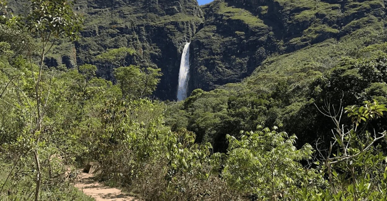 Trilha da Cachoeira Casca d’Anta com vista para a queda d’água, vegetação nativa e paredões da Serra