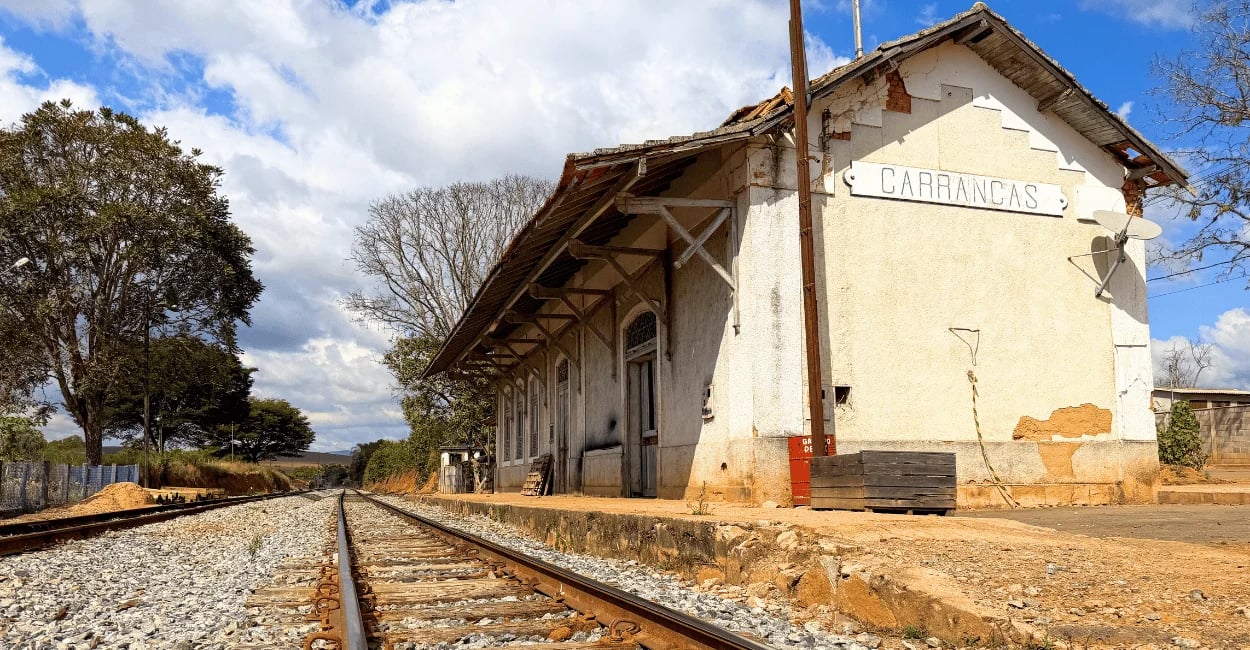 Prédio histórico da Estação Ferroviária de Carrancas ao lado da antiga linha férrea