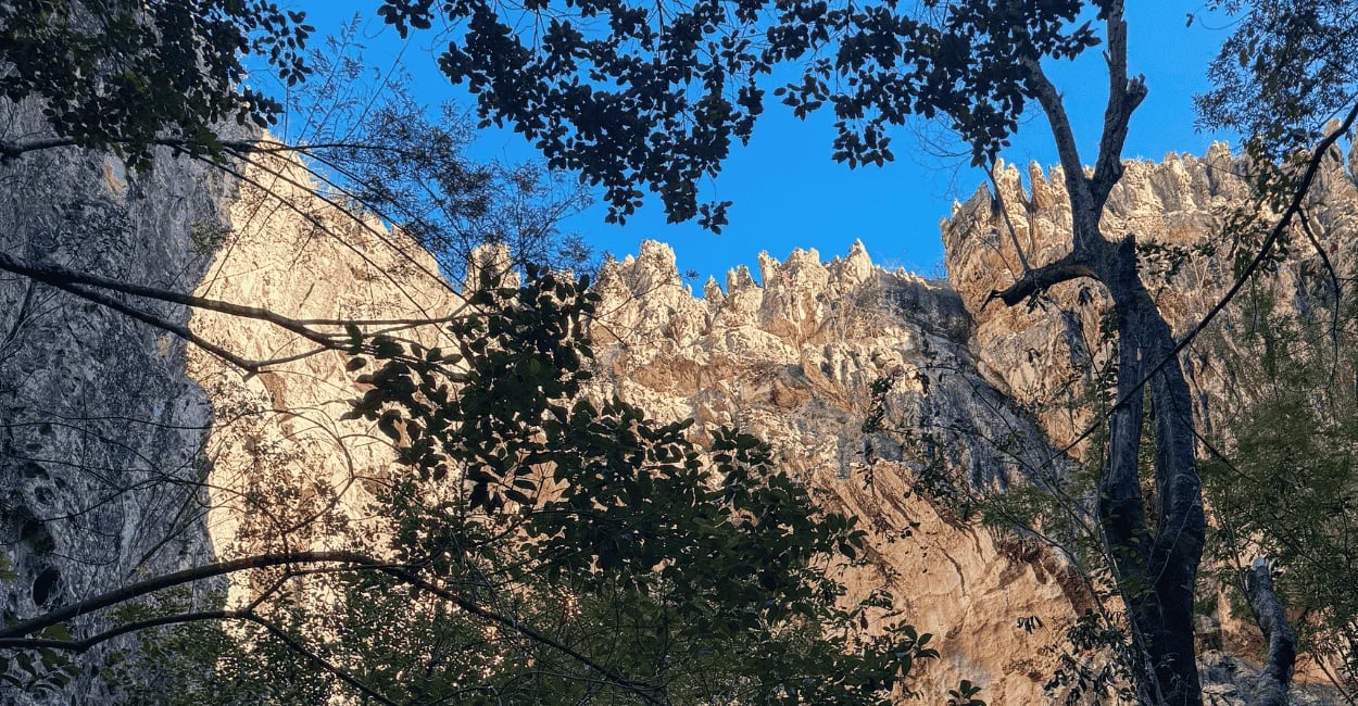 Gruta do Salitre em Diamantina MG com formações rochosas altas, vegetação sombreada e céu azul