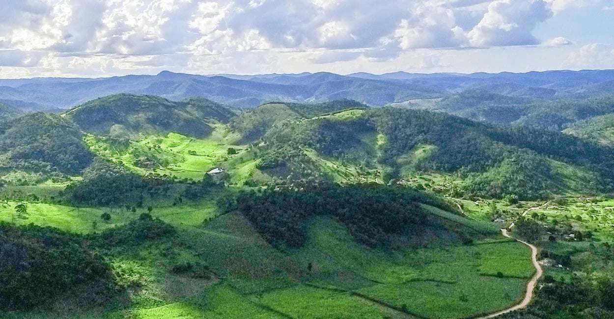 Vista panorâmica das montanhas, vales verdes e estrada de terra na zona rural de Concórdia do Mucuri
